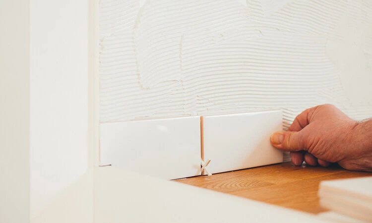 Handwerker beim Verlegen von Fliesen während Renovierungsarbeiten in Illertissen - Renovierung